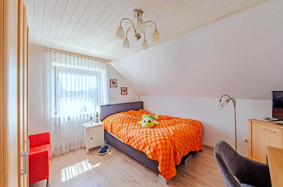 Drittes Schlafzimmer mit Dachschräge, Doppelbett und Fenster zur Gartenseite