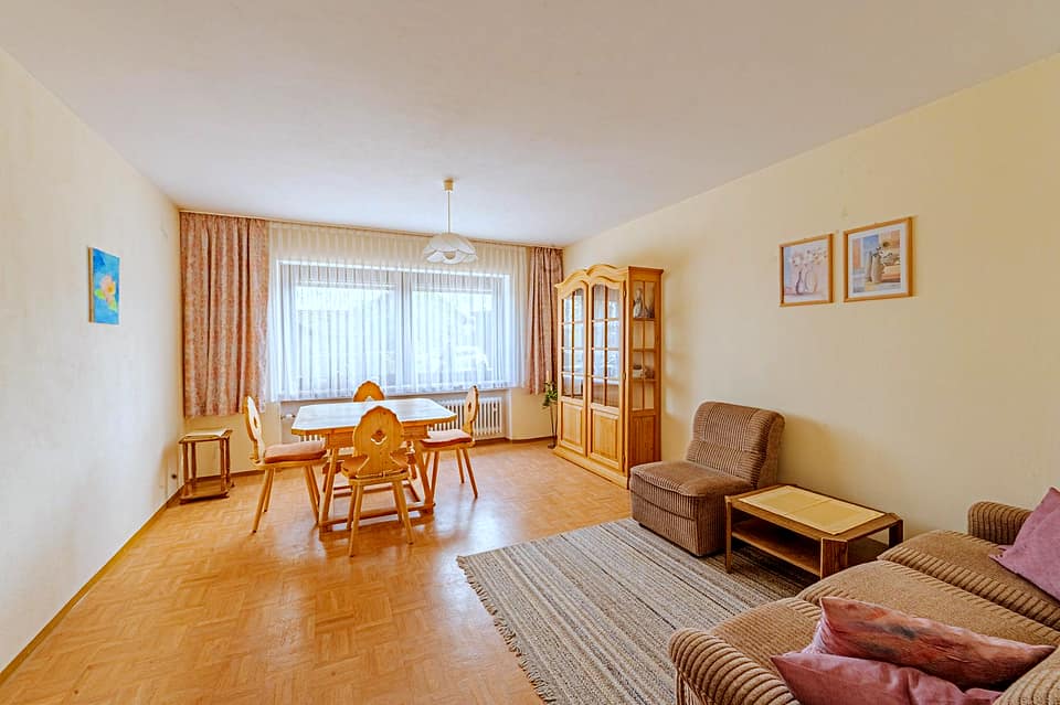 Wohnzimmer mit Essplatz, Polstergarnitur und Fenster zur Hofseite