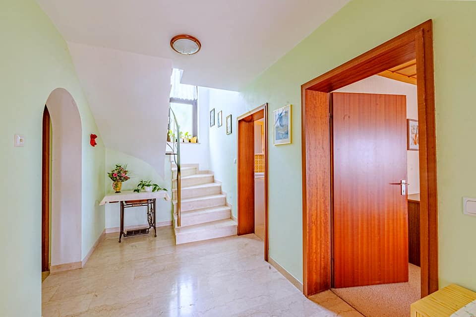 Diele mit Rundbogen, Treppe ins Obergeschoss und Holztüren