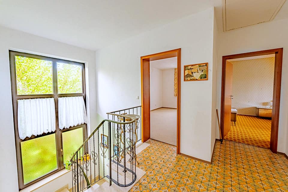 Flur im Obergeschoss mit Geländer, Fenster und Blick in zwei Zimmer