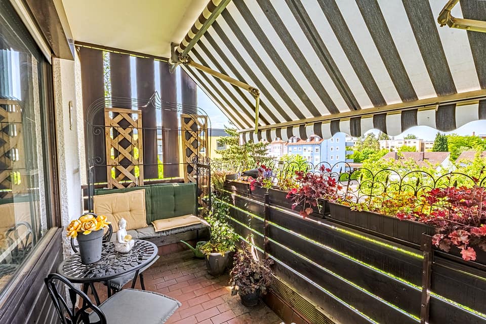 Balkon der Wohnung mit Markise, Blumenkästen und Blick ins Grüne