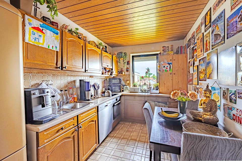 Küche mit Holzfronten, Holzdecke und Essplatz am Fenster