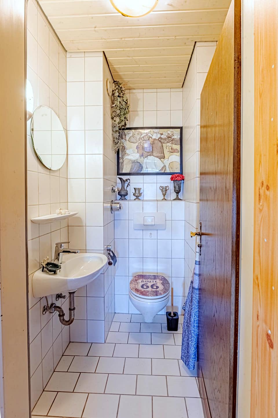 Gäste-WC mit Waschbecken und hellen Wandfliesen