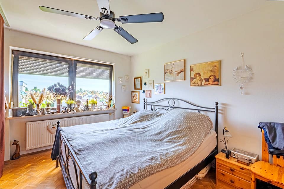 Schlafzimmer mit Doppelbett aus Metall und breiter Fensterfront