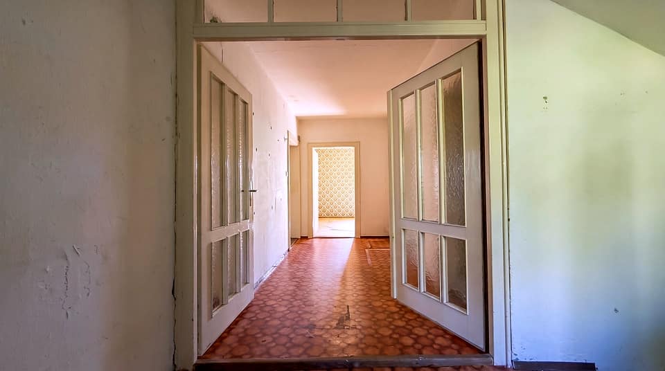 Diele mit zwei weißen Glastüren und Blick in den hinteren Flur
