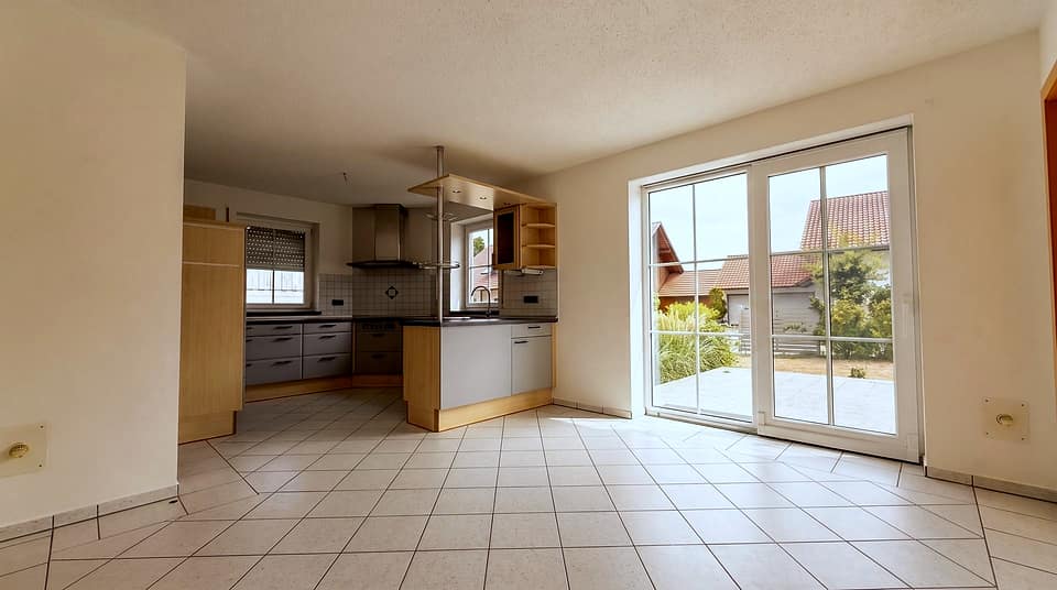Küche mit Kochinsel, Dunstabzug und Fensterfront zur Terrasse
