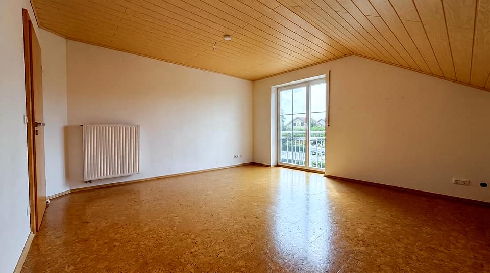 Zimmer im Obergeschoss mit Holzdecke, Korkboden und Balkontür