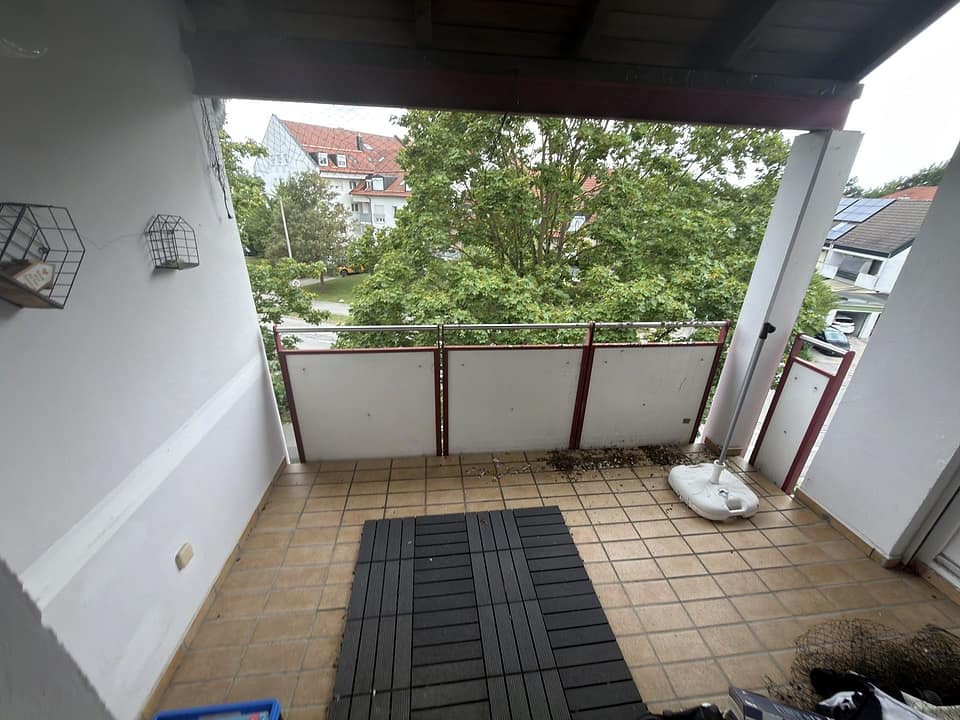 Überdachte Loggia mit Blick auf Bäume und Nachbarhäuser