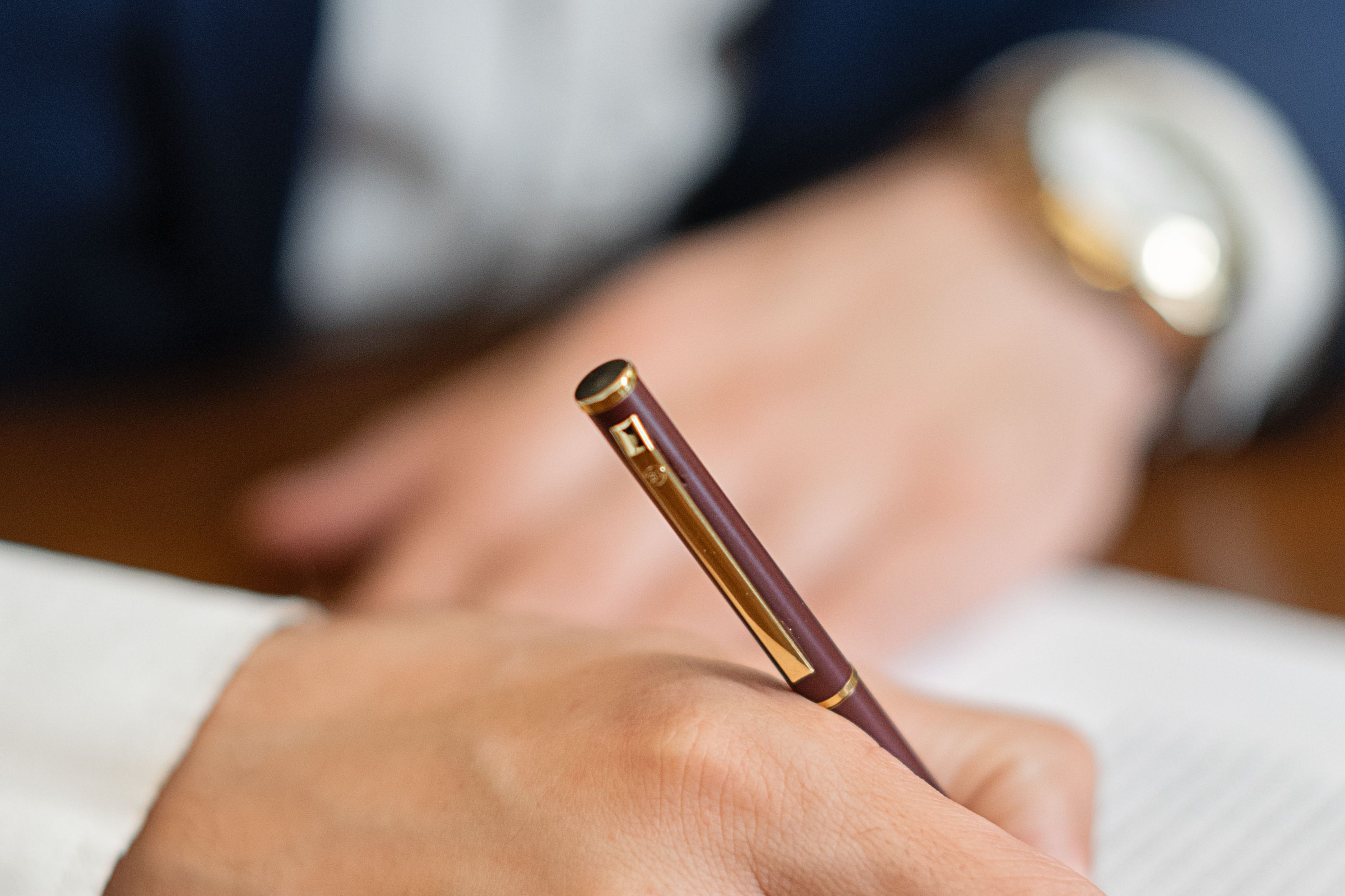 Eine Hand unterschreibt mit einem Füller ein Schriftstück