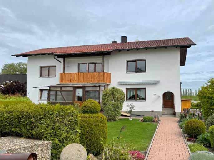 Weißes zweistöckiges Haus mit Holzbalkon
